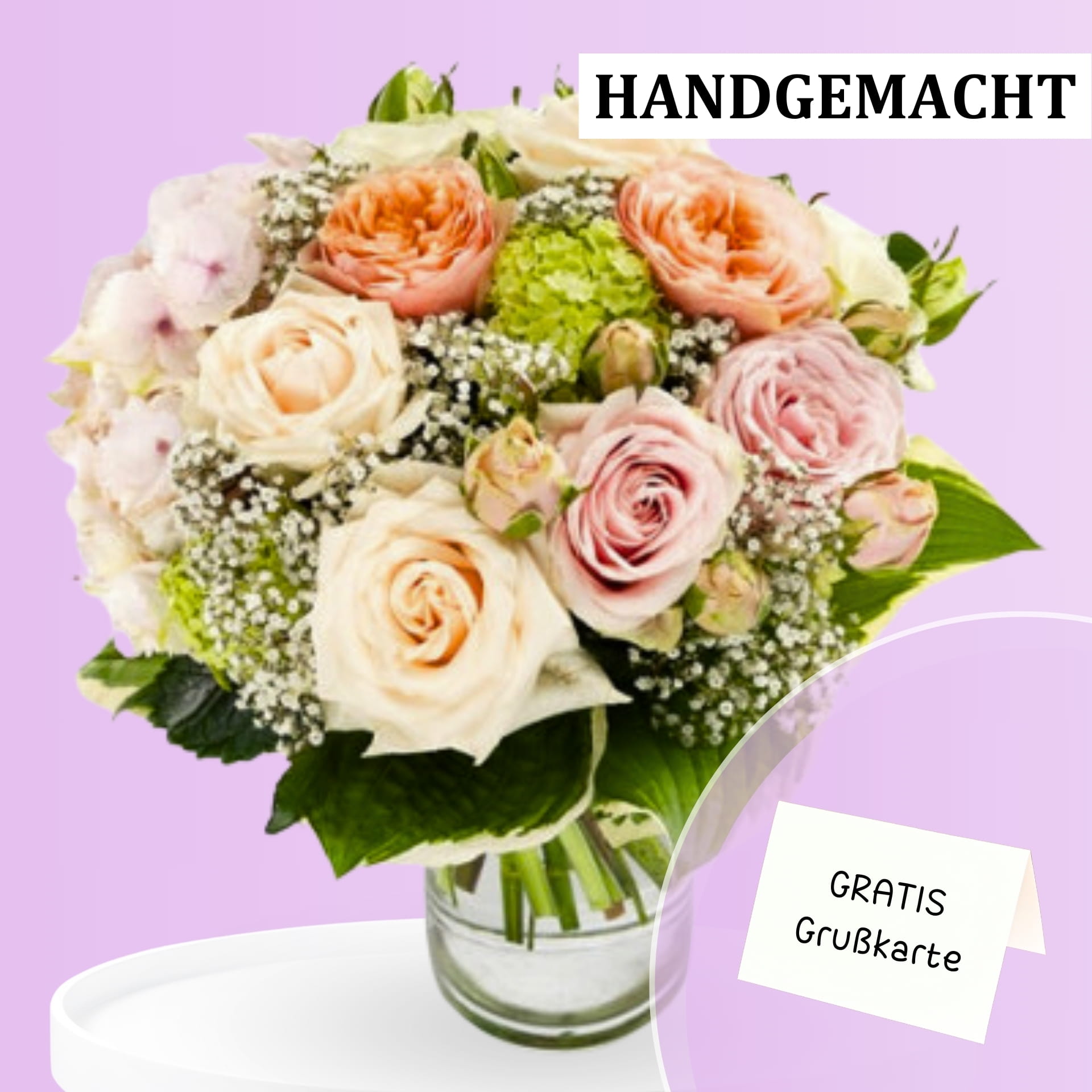 Blumenstrauß mit kostenlosen Grußkarte - FlowersdDeluxe Blumenversand Ein eleganter Strauß aus pastellfarbenen Rosen, grünen Blättern und Schleierkraut in einer Glasvase.