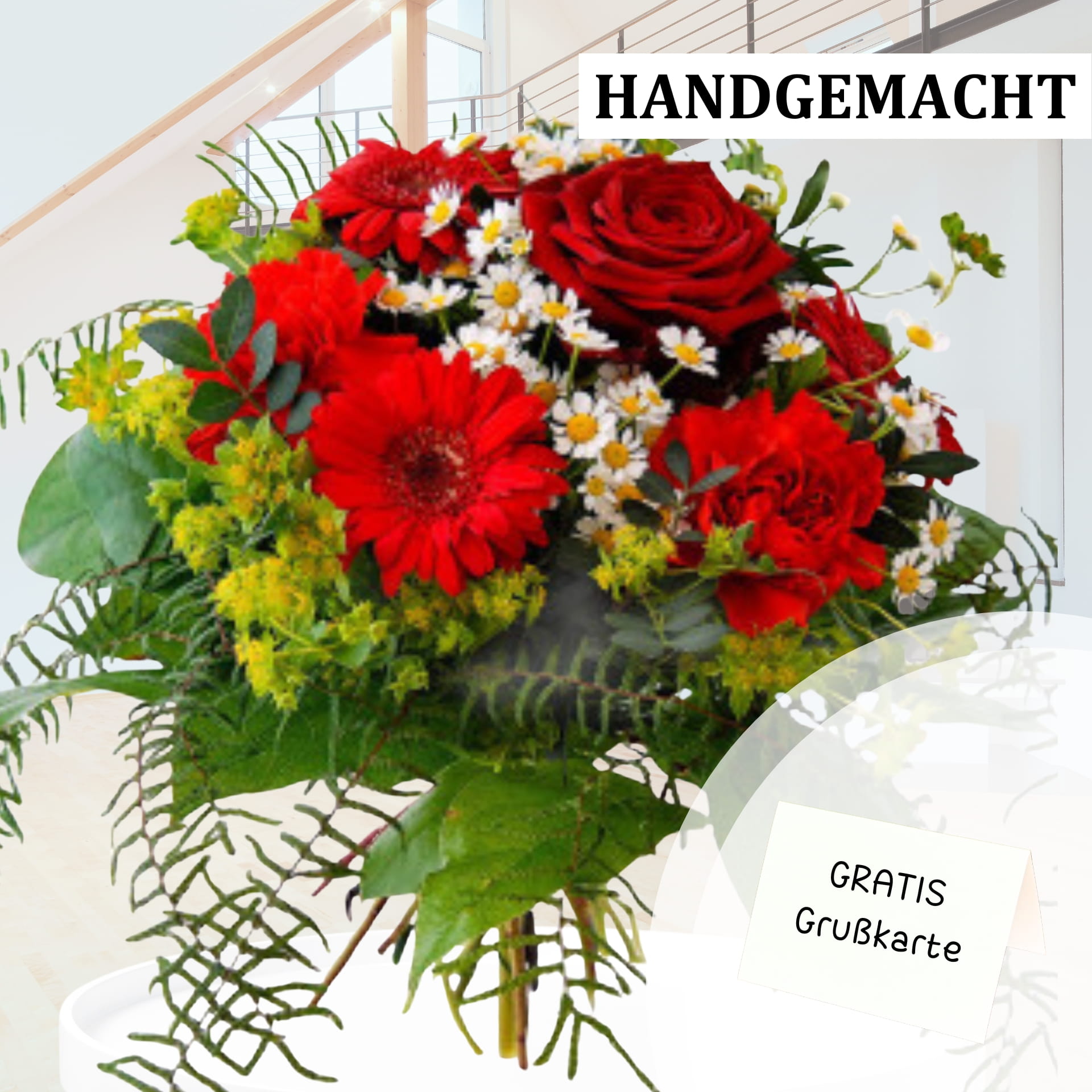 Leuchtend roter Rosenstrauß mit Gratis-Grußkarte Handgefertigter Blumenstrauß mit leuchtend roten Rosen, roten Gerbera und zarten weißen Blüten, eingerahmt von grünen Blättern in einem modernen Interieur.
